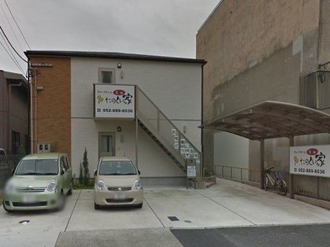 敷地内の駐車スペースに停められた2台の自動車と1台の自転車