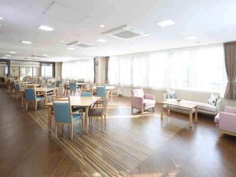 窓際にはソファとテーブルが配置されている。大きな窓に取り付けられたカーテンの色はブラウンで、床の色と統一されている。