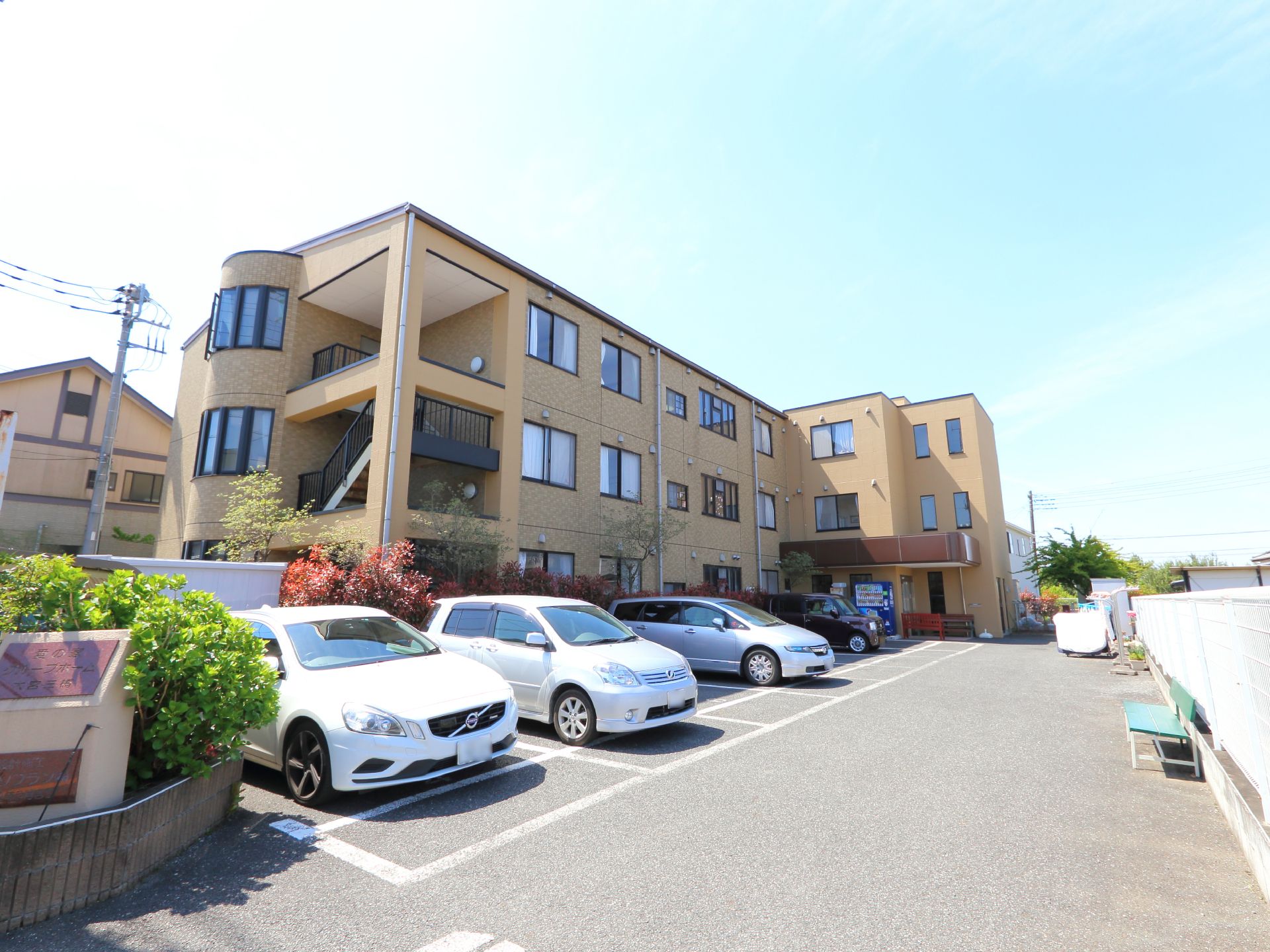 自然豊かな土地に建っている濃いベージュ色の3階建の建物である。広い駐車場を備えている。緊急時に利用する外階段も設けられている。