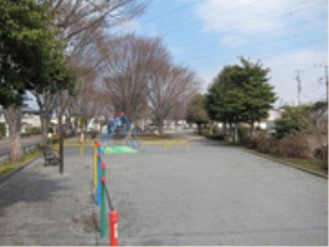細かい砂利で整備された敷地にブランコや鉄棒が設置されている。敷地の周りに落葉樹や常緑樹が植えられている。