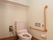 それぞれの居室には個人用のトイレが設けられている。肘掛けは背中側の壁に収納できる折りたたみ式になっている。
