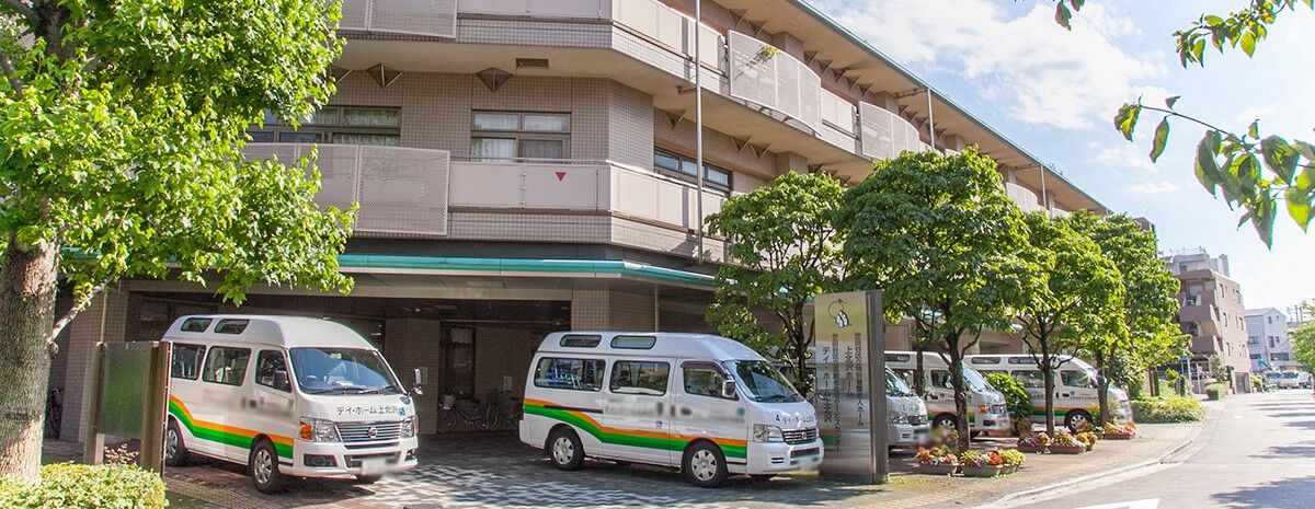 送迎車が並ぶ建物前