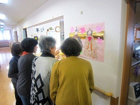 手作りのひな祭りの飾り付けのポスターを見て楽しむ利用者