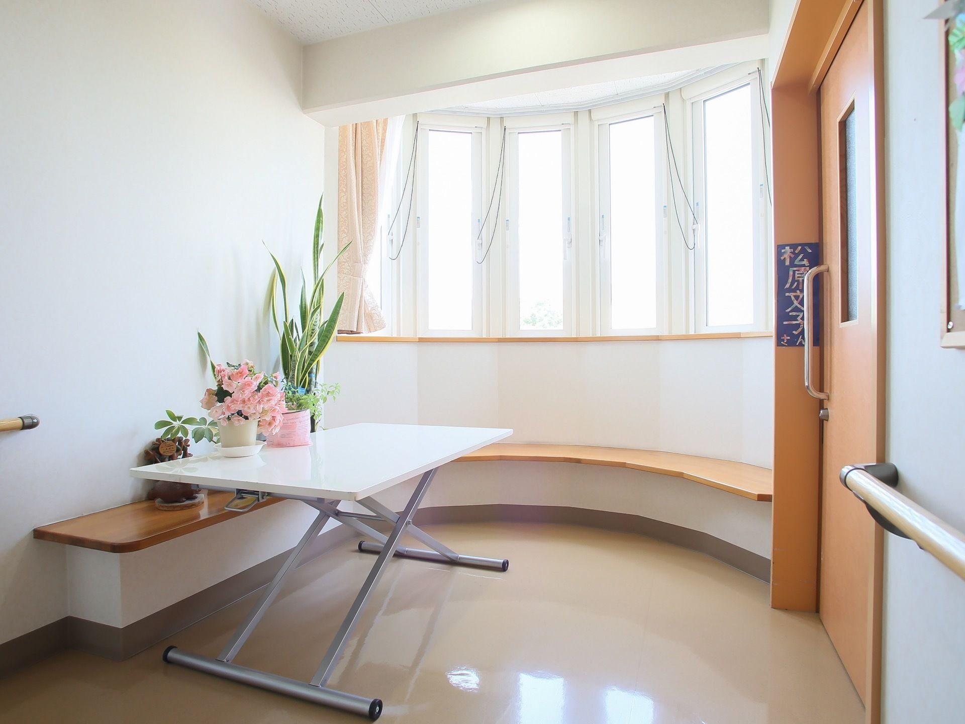 正面はカーブを描いたポーチになっており、出窓になっている。壁に沿ってベンチが取り付けられ、大きなテーブルが置かれている。