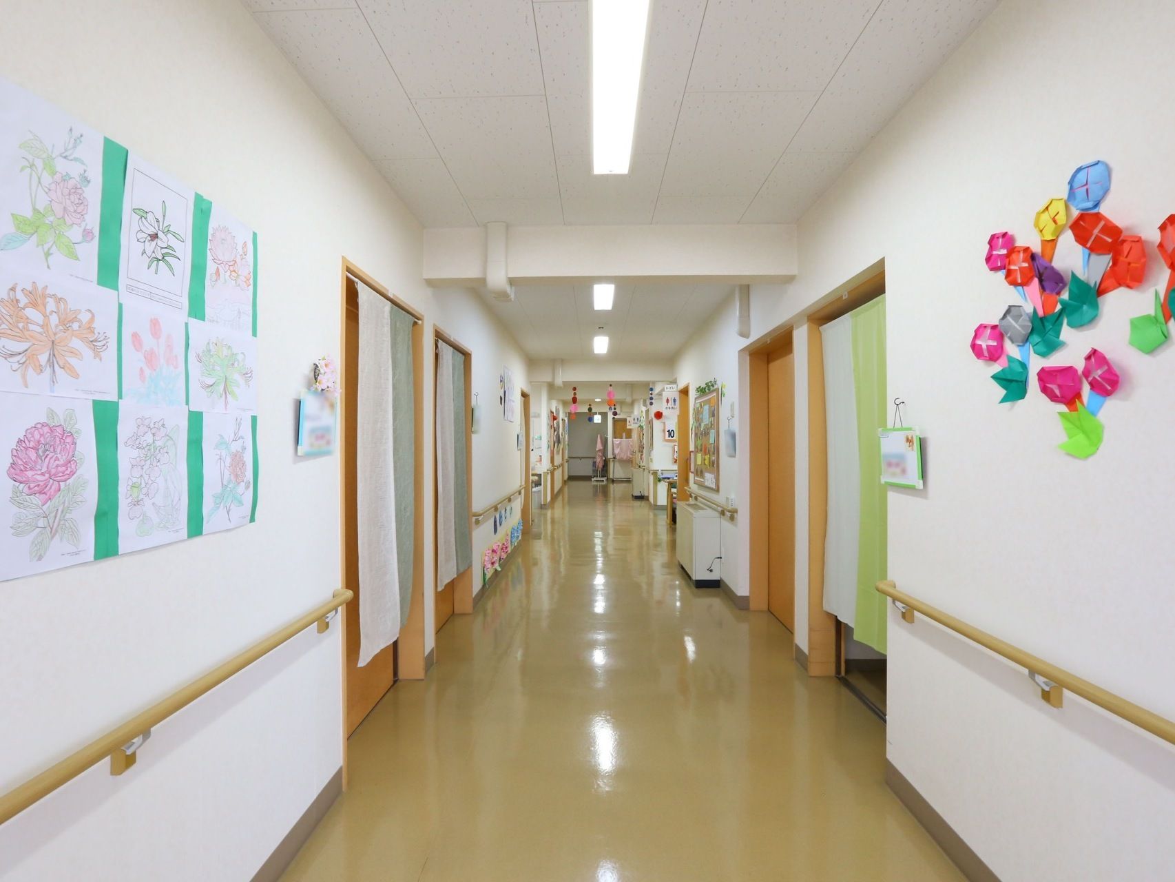 廊下と各部屋の間は、段差のないフラットな床となっている。壁には手作りの装飾が施されており、天井には等間隔で蛍光灯が設置されている。