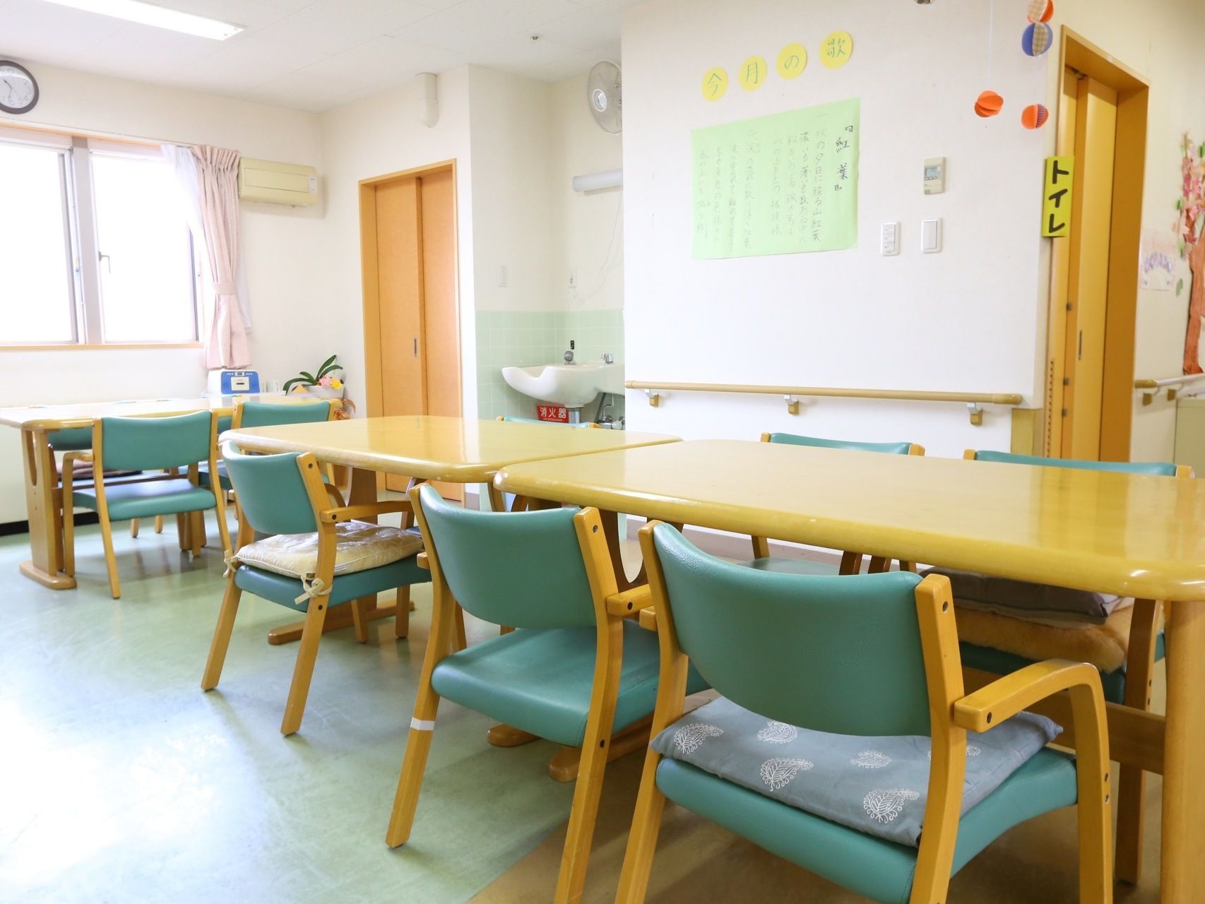 室内には木のテーブルと緑色のデザインの椅子が並べられている。床は木目調と緑色のツートンカラーが特徴である。