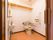 車椅子でも十分入れる広さのトイレである。L字型の手すりとひじ掛け手すりが設置されている。洗面台やペーパータオルホルダーが取り付けてある。