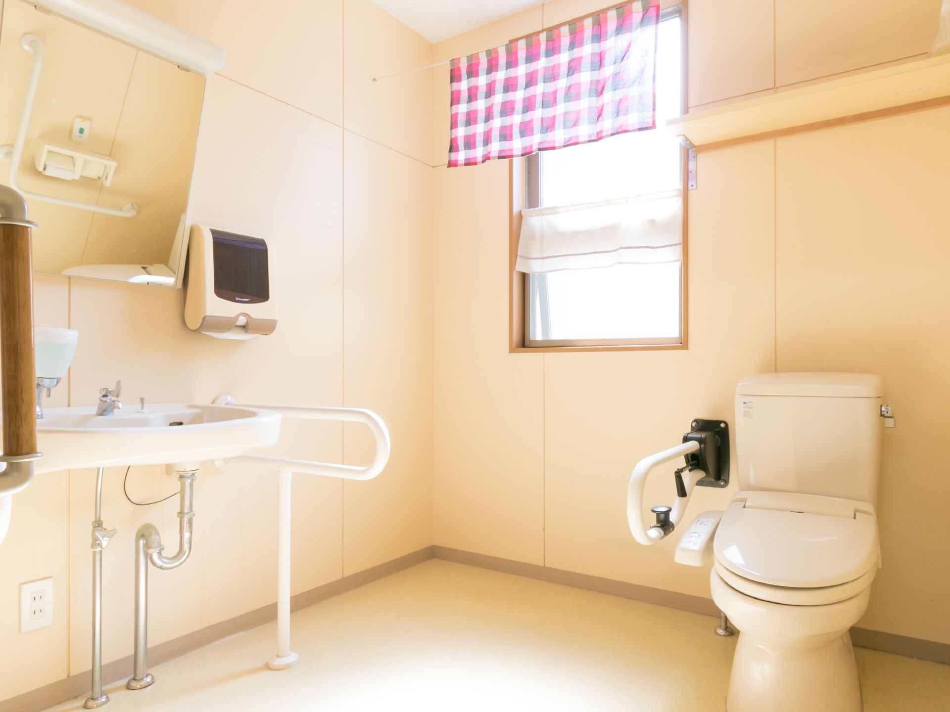 トイレは洋式。便座・洗面台の近くに手すりが設置されている。車椅子の方でも問題なく利用できるようスペースが広い。
