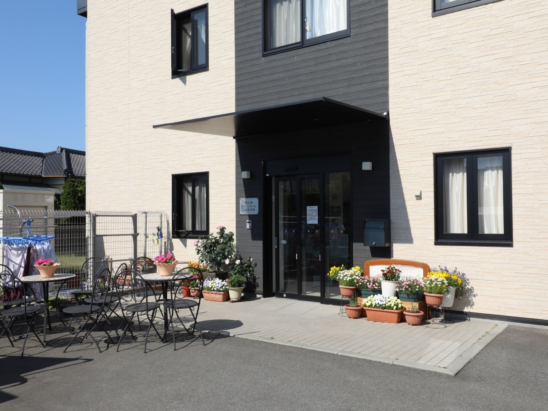 外観はベージュと黒を基調としていてモダンな雰囲気である。玄関ポーチには屋根が設けられ、玄関前はフラットで広々としている。