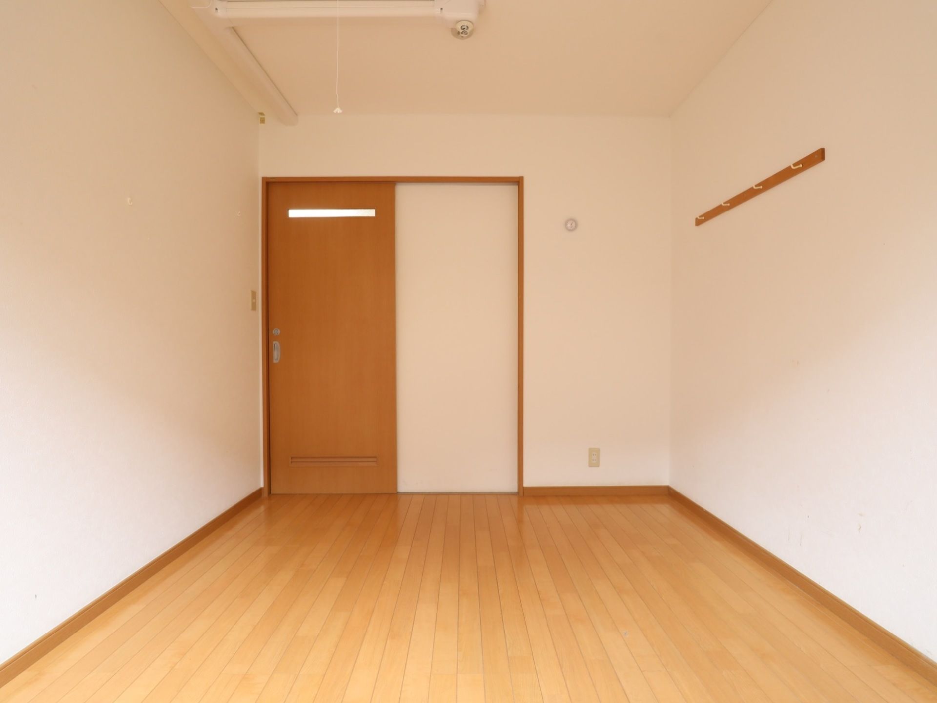 白い壁にやさしい配色の木目を基調にした温かみのある居室である。居室扉はスライド式になっておりスムーズな開閉ができる。