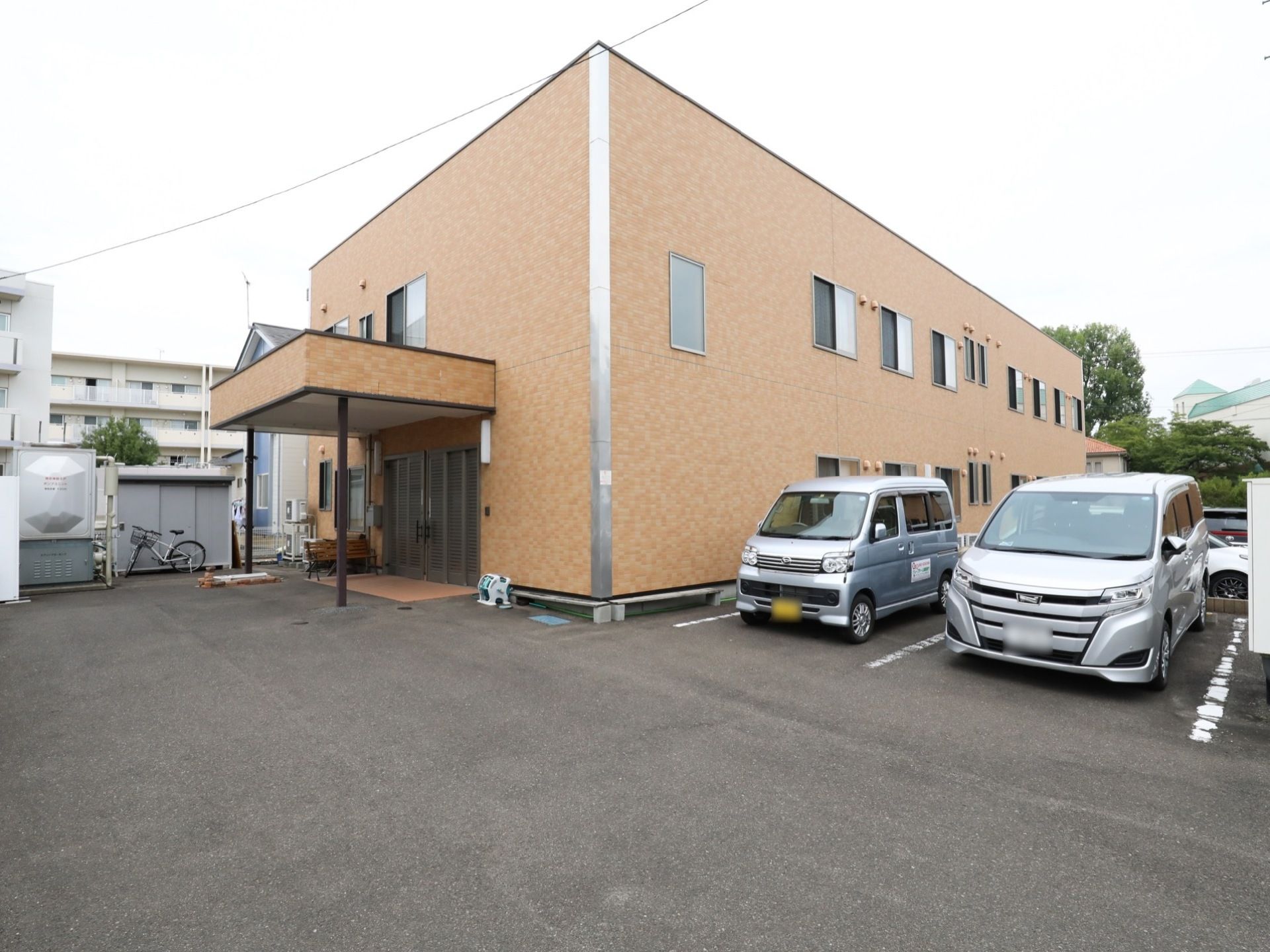 施設の建物は、外壁がレンガ色の２階建てである。エントランス部分には雨除け屋根があり、敷地内には駐車場が完備されている。