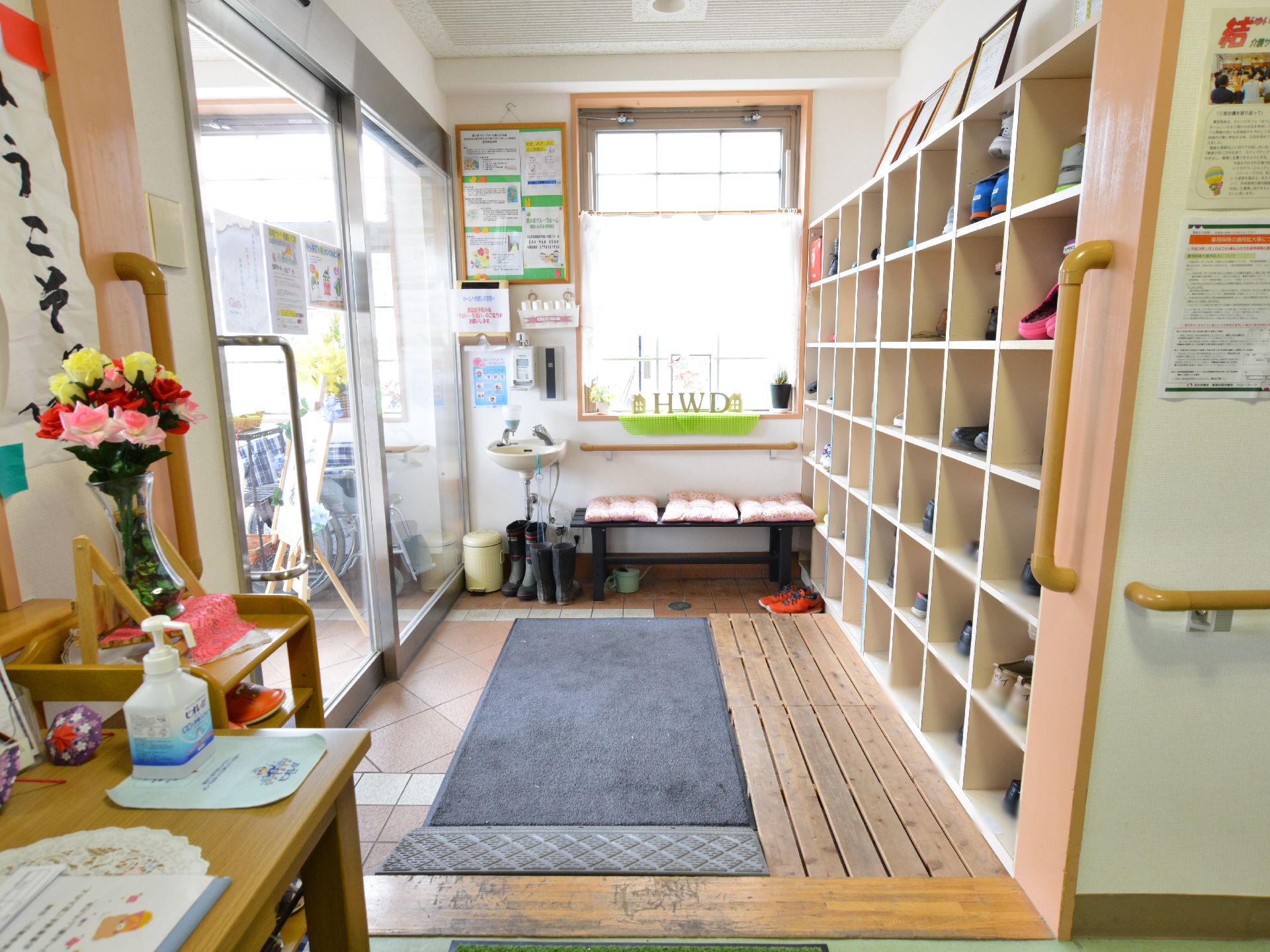 入り口を入ると、6段ある大型の下駄箱が設置されている。靴を脱ぎ履きするすのこが置かれ、段差をなくすパーツも置いてある。