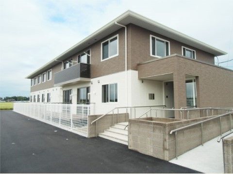ブラウンが基調の２階建ての建物である。物干し台が完備されているベランダでは、天気のよい日に洗濯物が干せる。