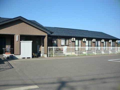ソーラーパネルを完備している平屋建ての建物である。駐車場と建物の間にはフェンスが立てられているので、車の誤進入がなく安全である。