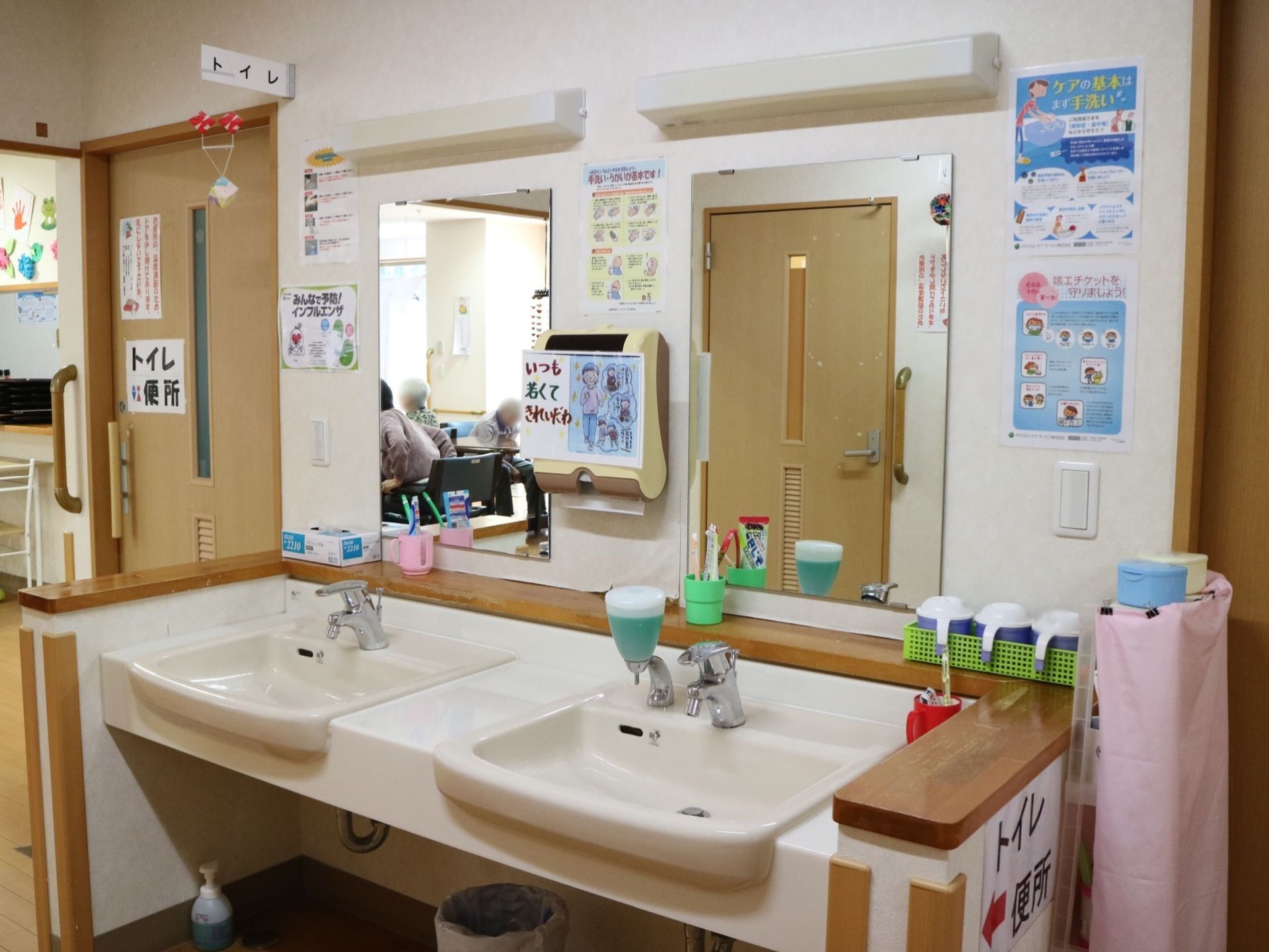 トイレの隣には洗面台が２つ並んで置かれている。鏡と照明がついており、２つの洗面台の間にはペーパータオルが掛けてある。