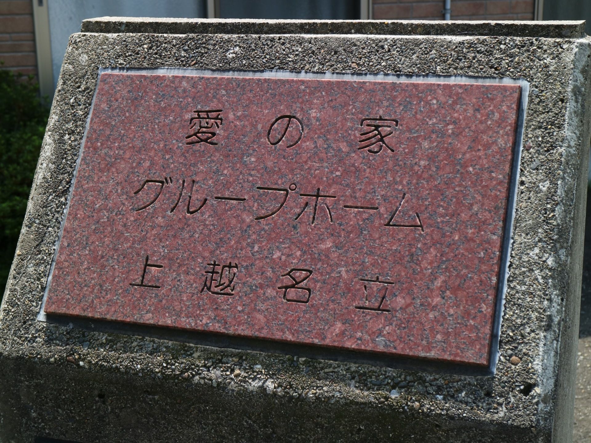 施設近くにある歩道沿いの植え込みには、施設表示が設置されている。歩道を通る人など周辺住民にも分かるように大きな文字の表示である。