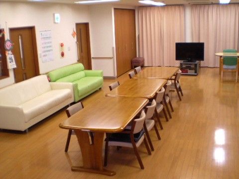 明るく清潔感のあるリビングである。大型液晶テレビや４人掛けのダイニングテーブル、ソファが完備されゆっくりとくつろげる。