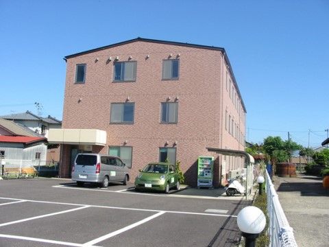 ３階建てのブラウン系のモダンな建物である。エントランスの横には車椅子専用駐車場や自動販売機が完備されている。
