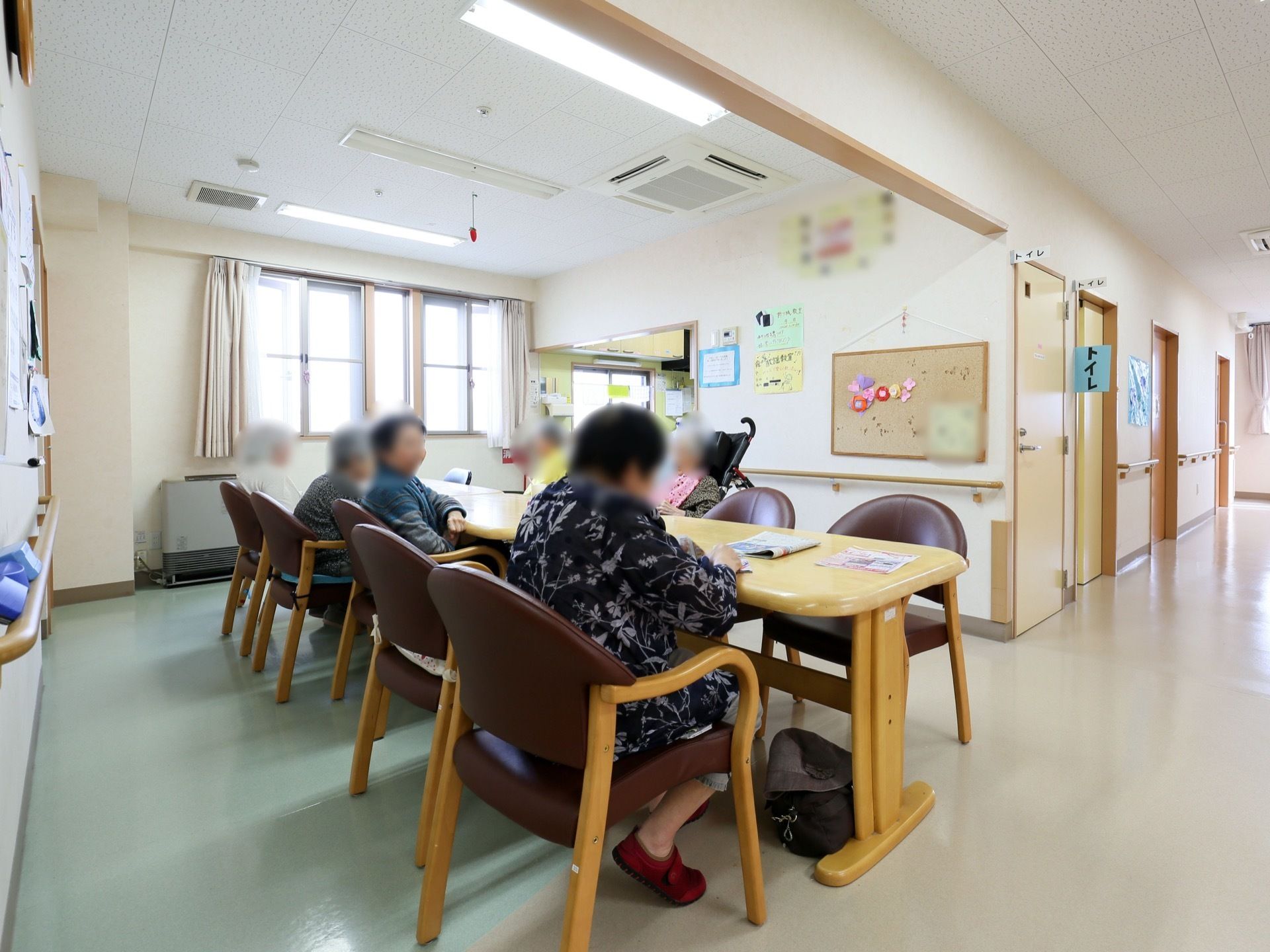 通路を真っすぐ進んでいくと、広々とした共有スペースにたどり着く。入居者様が複数人座ることのできる、テーブル席がある。