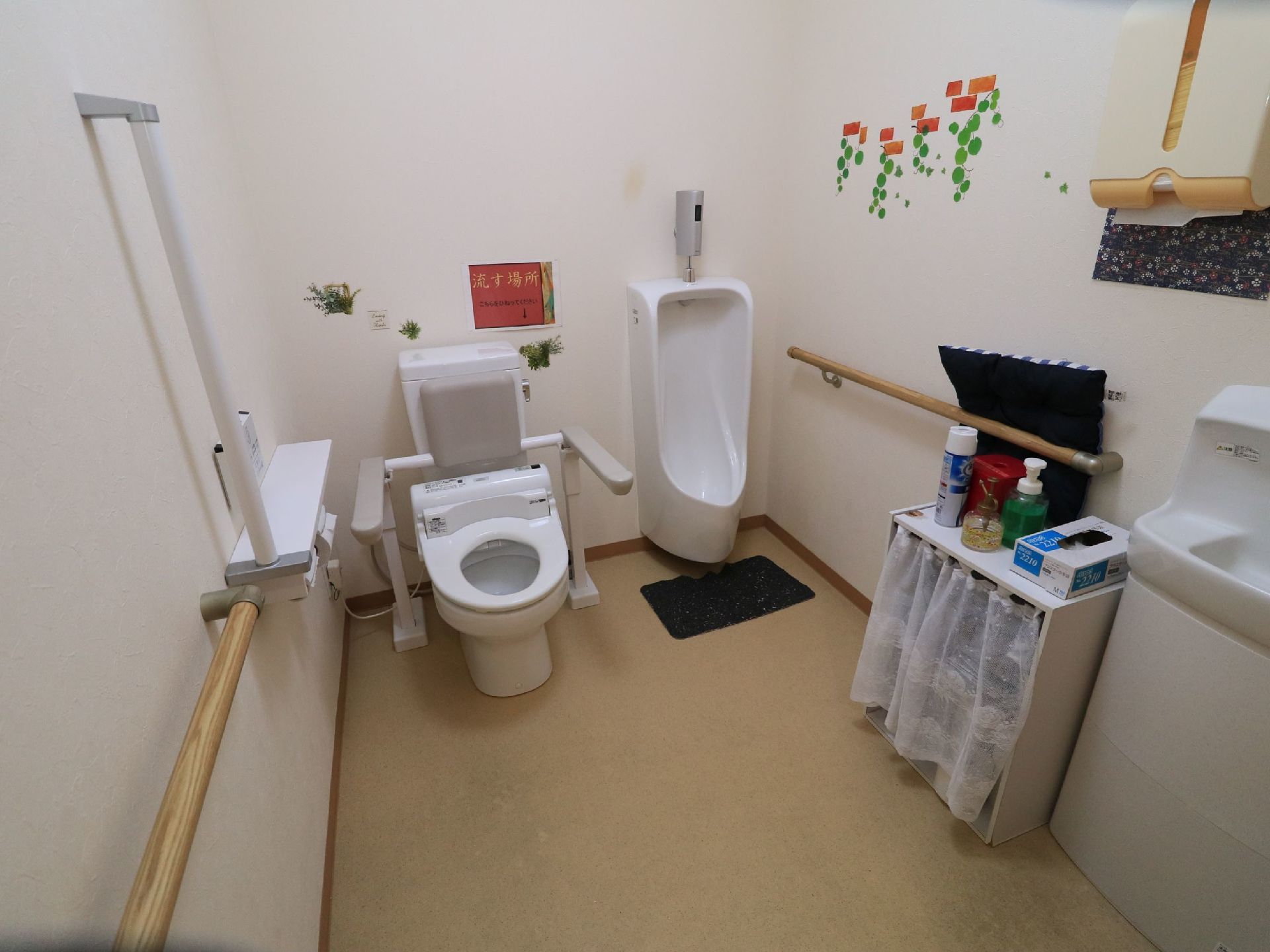 トイレには、洗面台や手すり付きの背もたれパッドが設置された温水洗浄便座器や、男性用の小便器が完備されている。