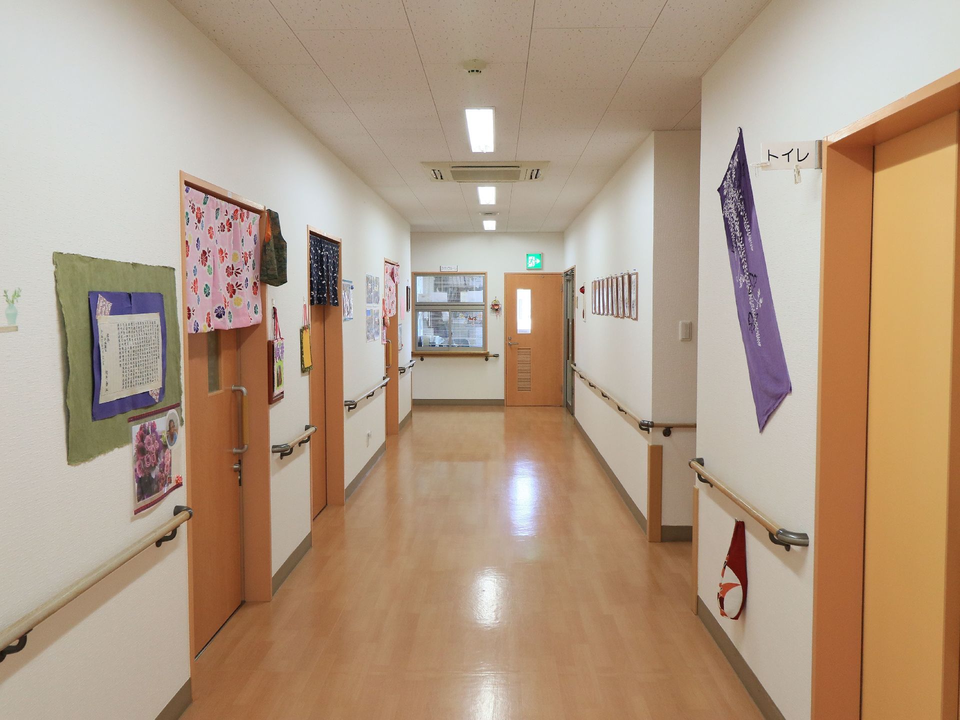 通路は広々としていて壁に手すりが取りつけられている。各部屋の入り口には色とりどりの暖簾がかけられている。