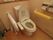 トイレには、壁と便器横の２か所に手すりが取りつけられている。それぞれに白と黄色のクッション材が巻かれている。