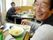 この日のメニューはラーメンで、野菜が多くトッピングされた食べごたえのあるものである。手前の入居者様は、笑顔で箸をつけている。