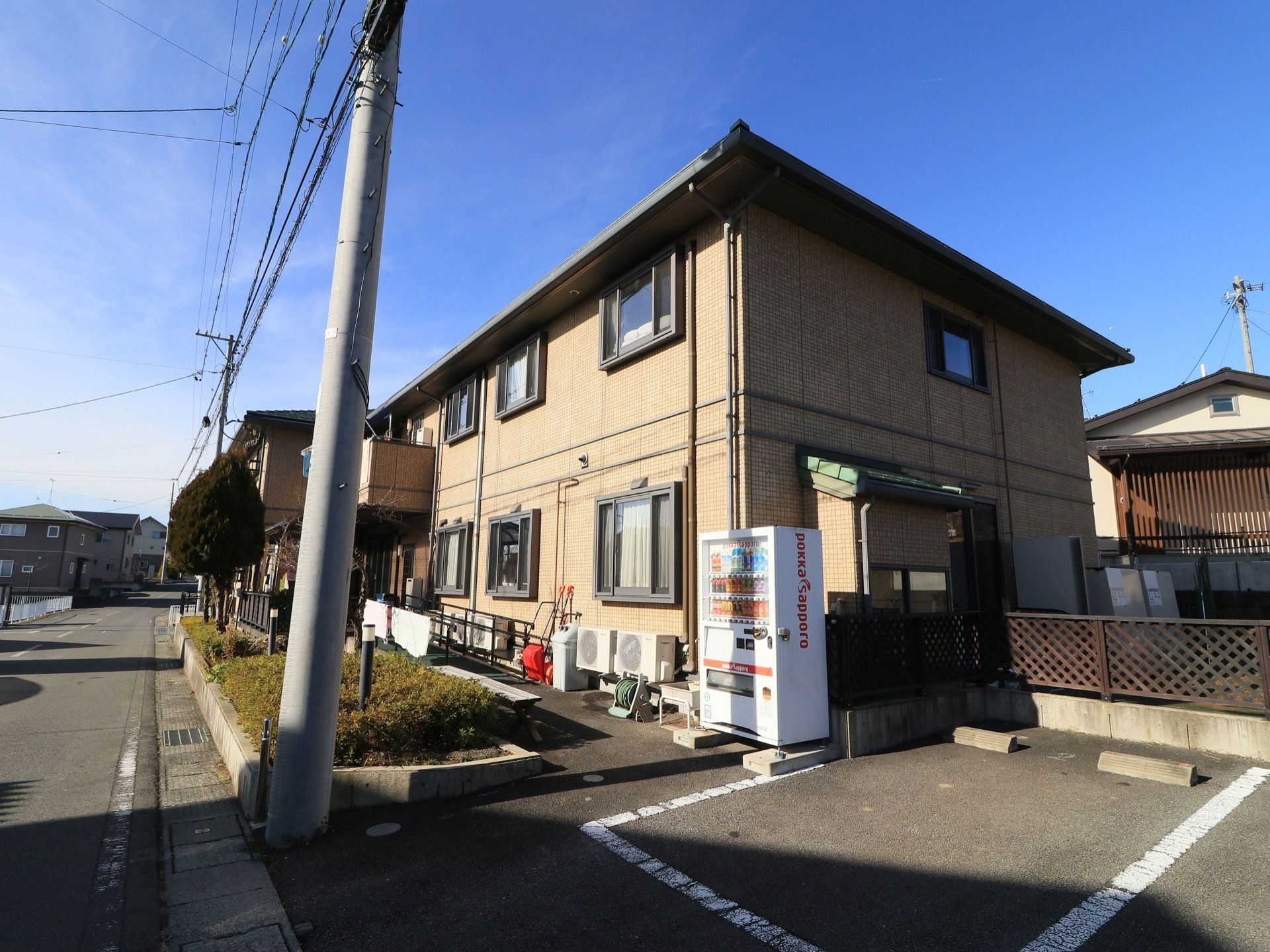 ２階建ての施設である。建物脇に自動販売機が設置され、そのすぐ横が駐車場になっている。道路と建物の間には植え込みがある。
