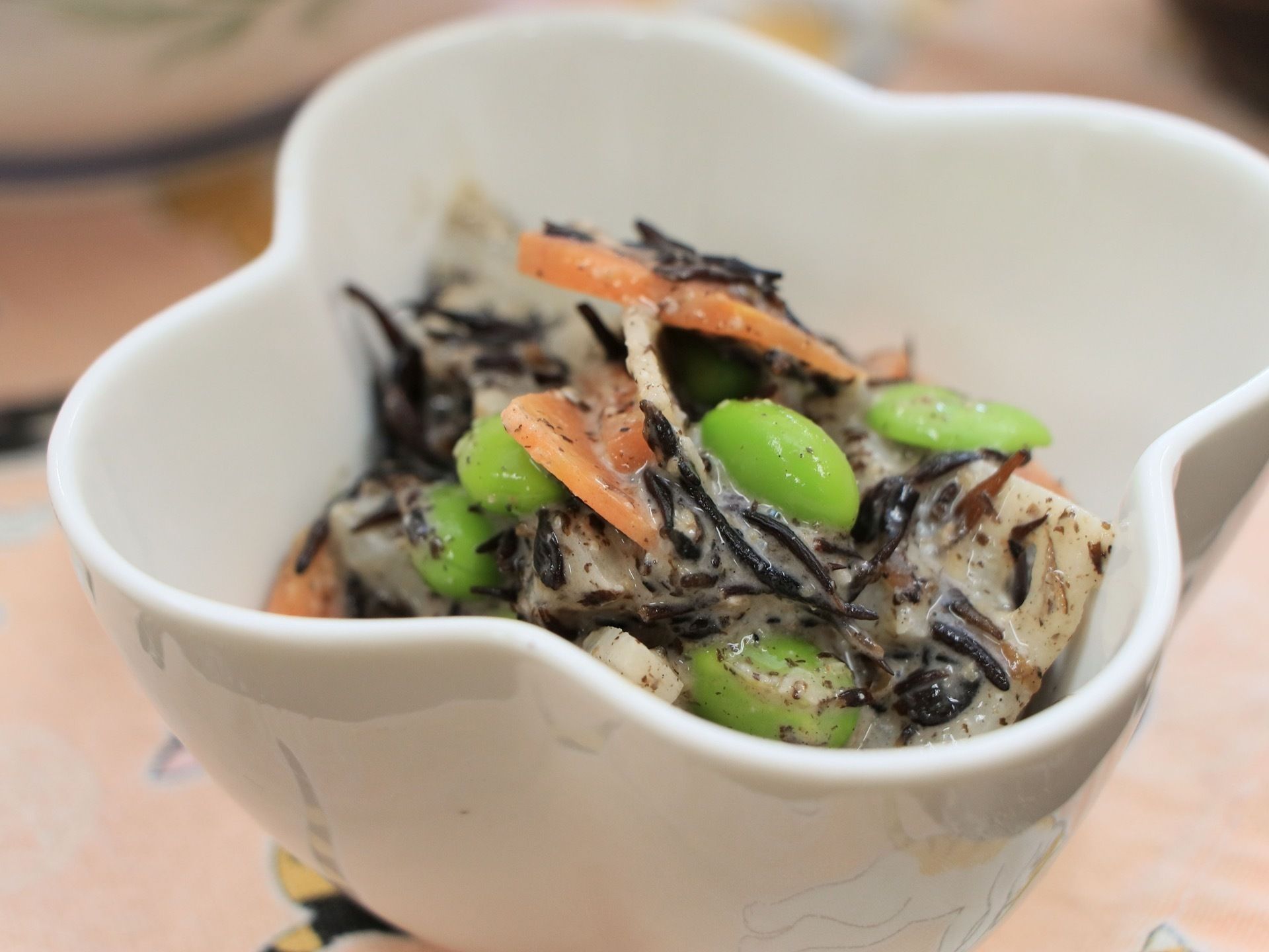 ひじき、人参、枝豆などを使ったカラフルな和え物が白い器に入っている。健康的で、食べやすい一品になっている。