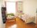 部屋にベッドとテーブルが置かれていて、壁には洋服掛けが取り付けられている。自身の家具を持ち込み、部屋のアレンジを楽しんでいる。