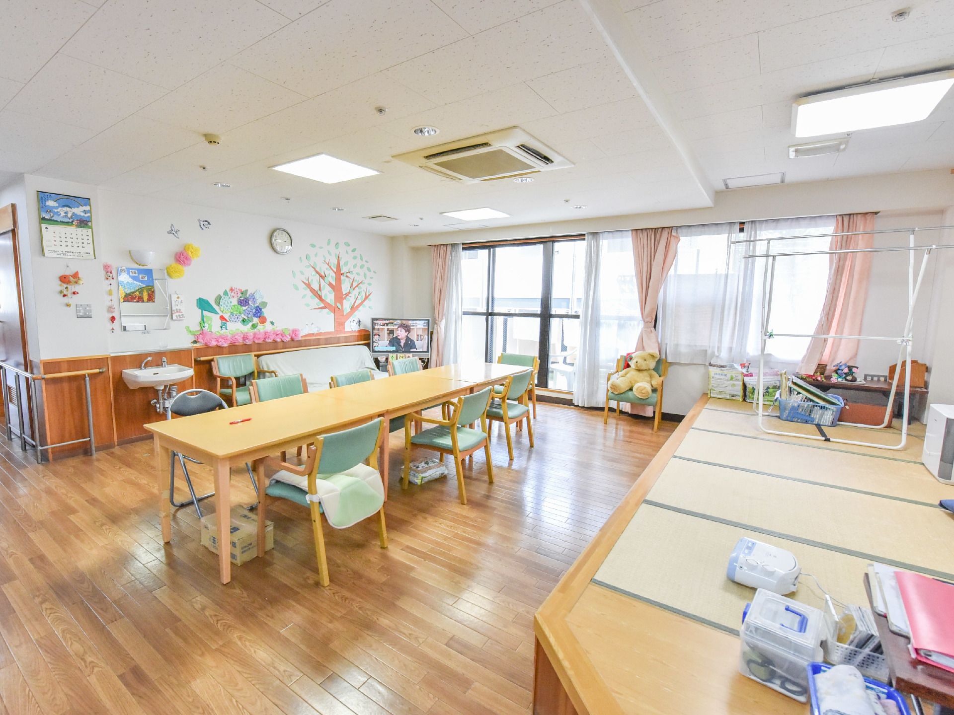 ダイニングルームの一面は大きな窓になっており、太陽光がはいるためとても明るい。壁と天井は白く、床は木材でナチュラル。