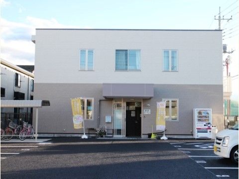 閑静な地域に位置し、広い駐車場とバリアフリーに対応した当施設の正面