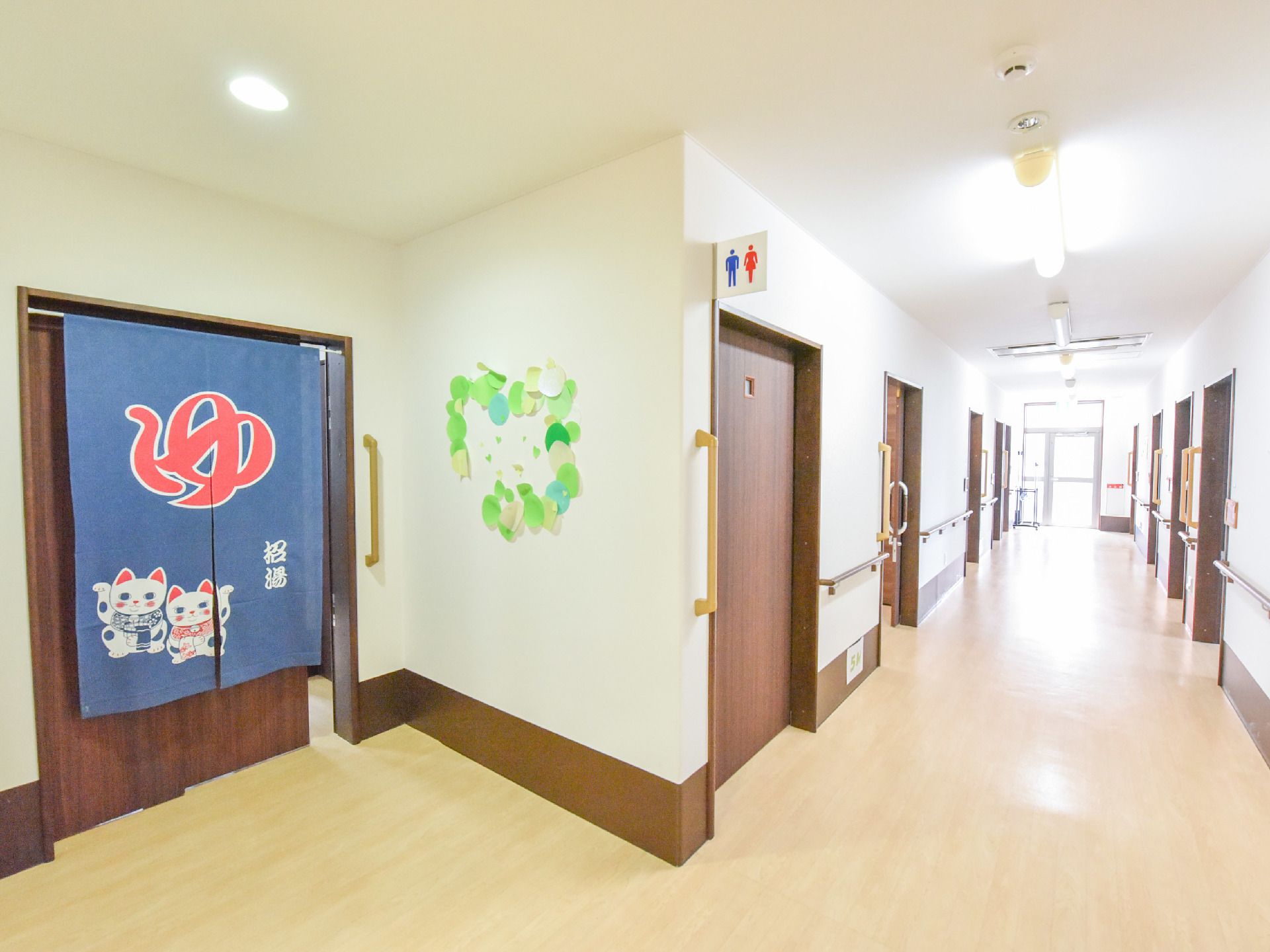 お風呂の入り口には銭湯のような暖簾がかけられている。手前にトイレがある。廊下には段差がなくフラットである。