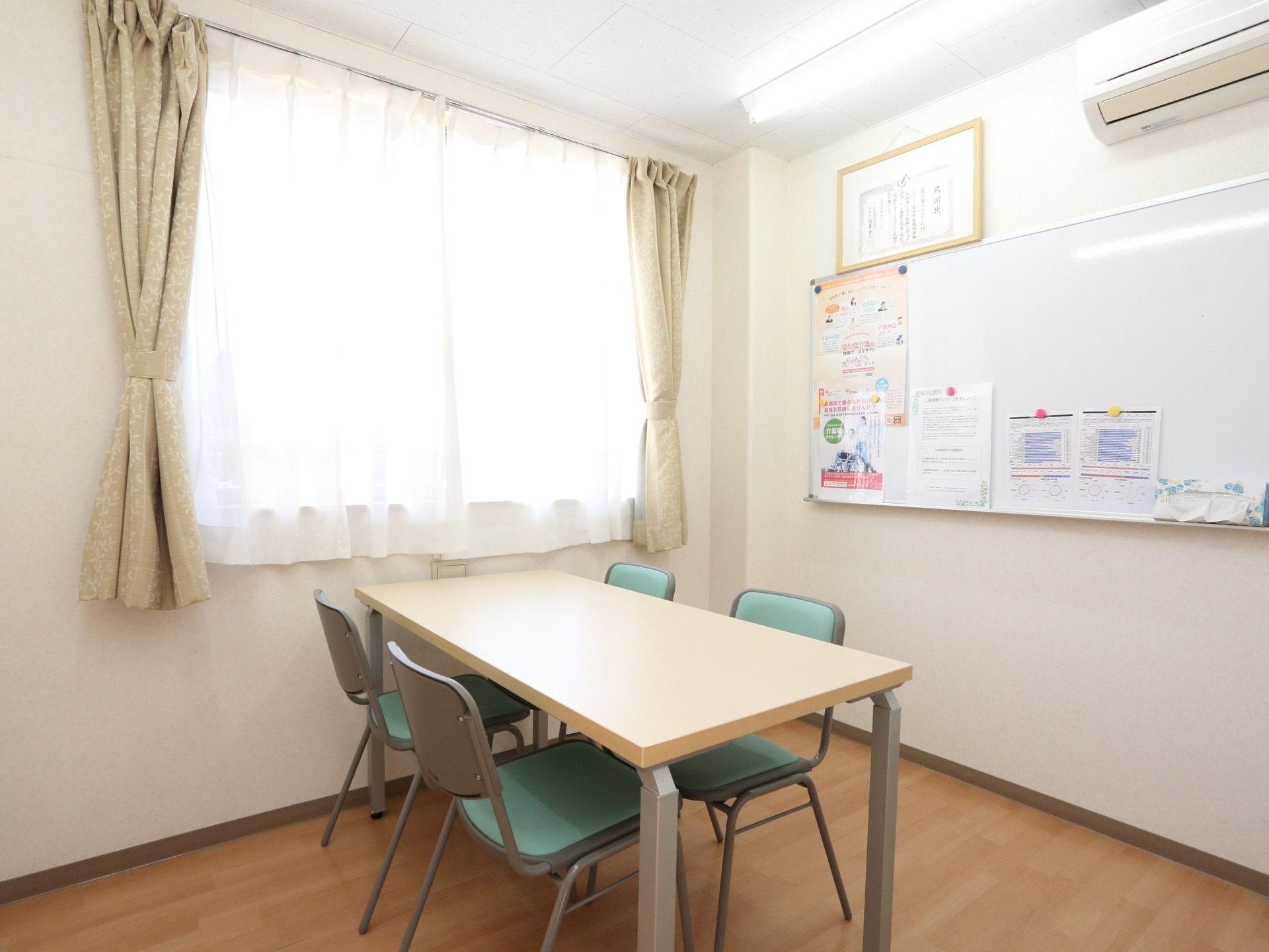 入居相談をされる方や入居者様のご家族と面談する部屋には、テーブルと椅子の他ホワイトボードがあり、施設の案内や説明書などが掲示されている。