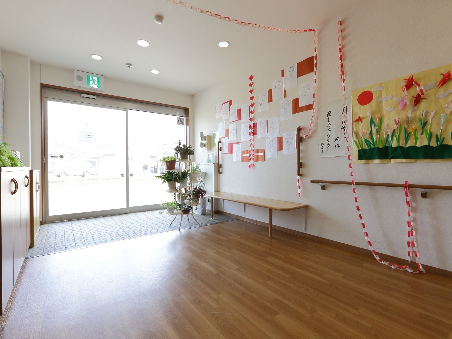 扉が大きいのでとても光が入る。明るい玄関となっている。靴箱やベンチが設置されている。段差がなく、バリアフリーとなっている。