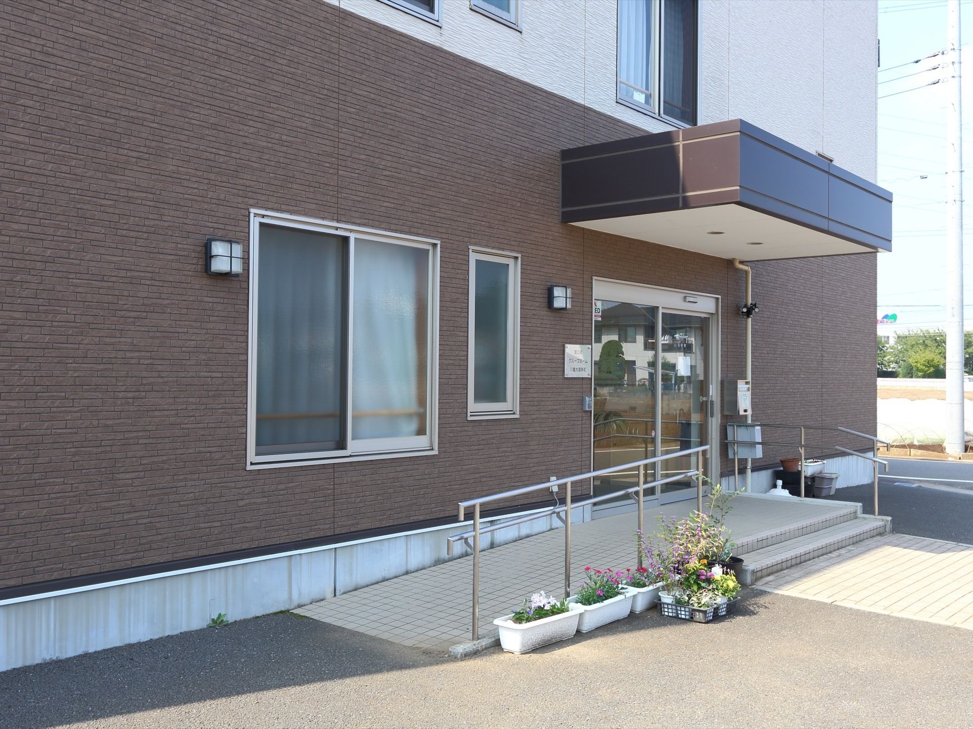 AEDのある施設である。入口前には階段、スロープが設置されている。自動の扉であり、利用しやすくなっている。