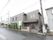 外観はグレーのシンプルな建物である。道路に面している。建物の前には数本木が植えられている。左右には建物が建っている。