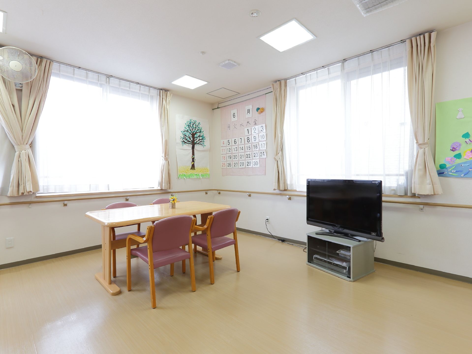 4人掛けの椅子とテーブルが設けられている。テレビも設置されている。広いスペースがとられている空間である。