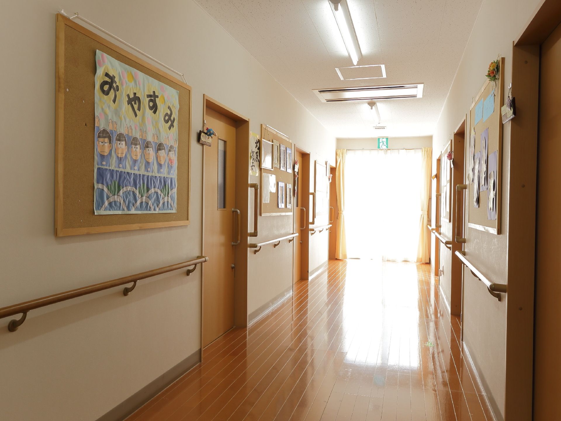 通路は車いすが通れる十分なスペースが設けられている。各部屋へと入る扉はスライド式となっている。壁には手作りの飾りがある。