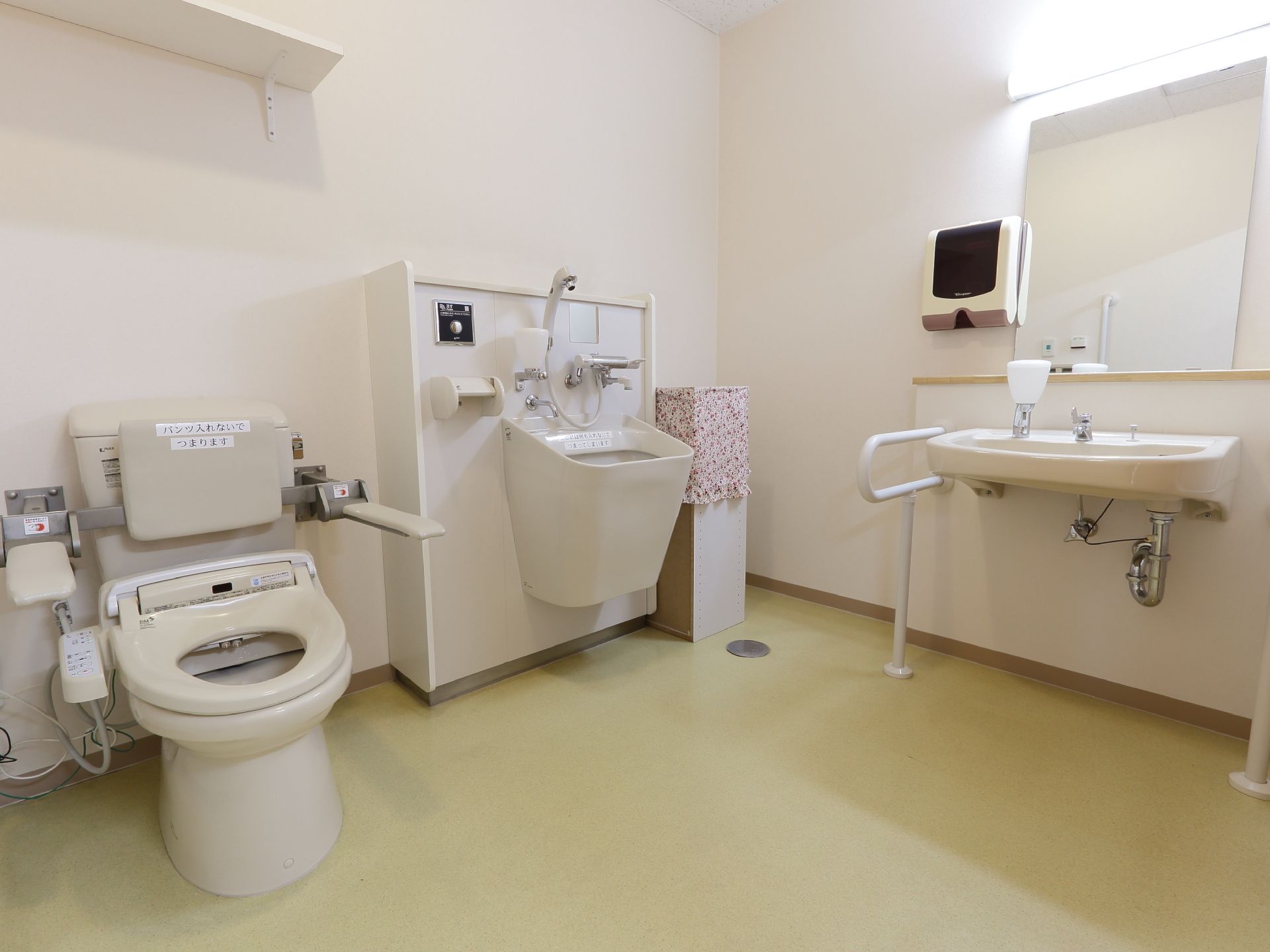 トイレにはバリアフリーの手すりが設けられている。便座には肘置きも設けられている。洗面台も大きく設けてある。