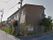 ホームの周りは白色のフェンスで囲っている。建物は、茶色いタイルを用いた２階建てである。２階の窓の上には換気口がある。