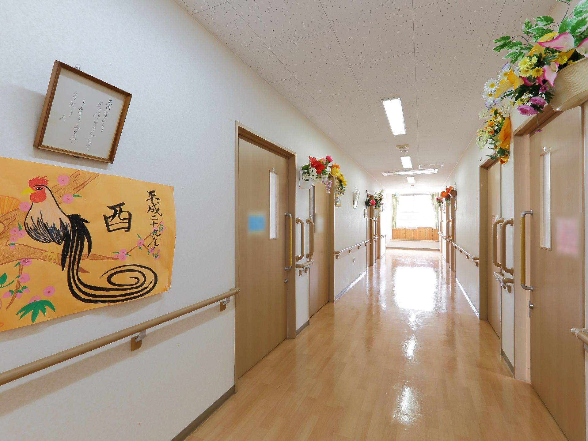 広々とした廊下には、壁に造花や絵などが賑やかに飾られている。縦横方向に手すりが付いており、伝い歩きが可能である。