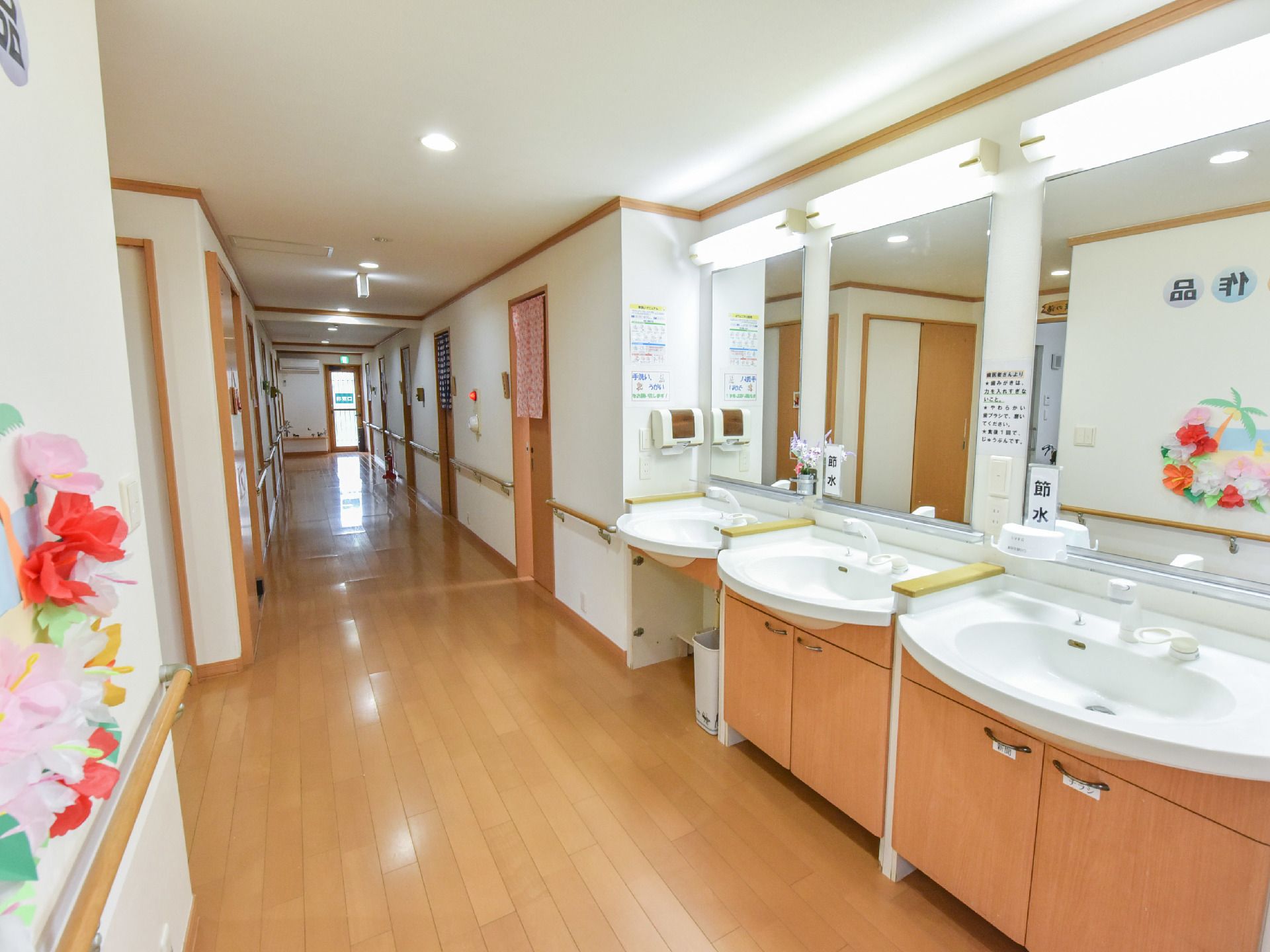 食前食後や外出後など、手洗いうがいに便利な洗面台。大きな鏡もついている。一番奥は車いすの方が利用しやすいよう足元は空いている。