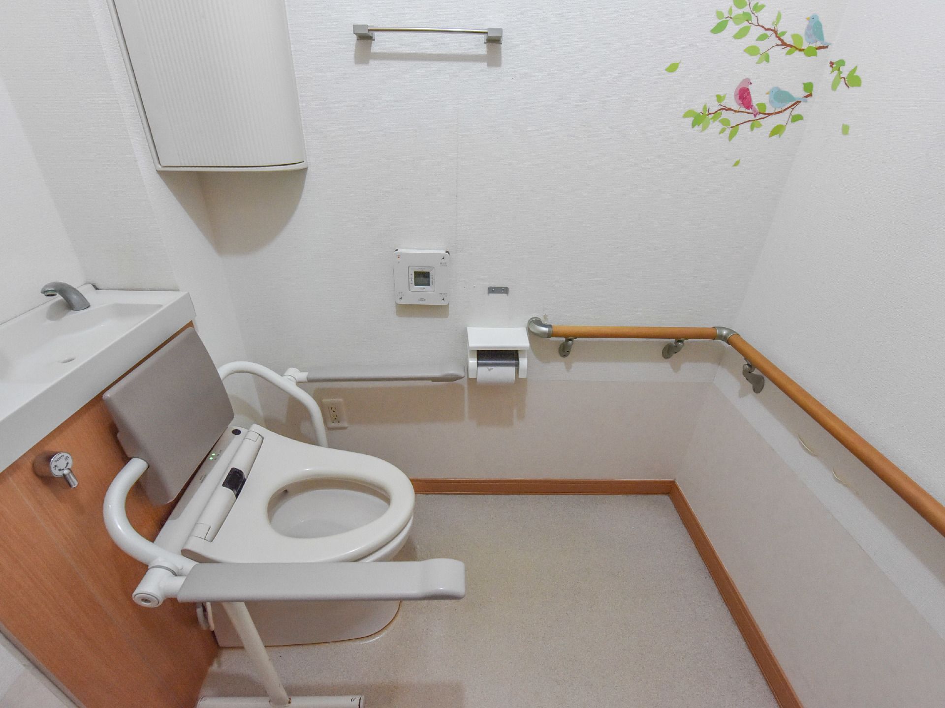 清潔感があり、機能的なトイレ。壁に沿ってトイレまで手すりがあり、つたっていきやすい。ウォールシールがかわいらしい。