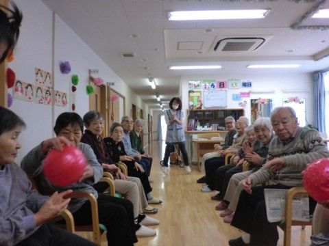 ２列の対面で椅子に座り、隣の人に順にボールを受け渡していく運動