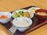 黒のトレーの上にご飯と汁物、メインのおかずと小鉢が2つのバランスのとれた食事メニュー。食事の量も高齢者向けに考慮されている。