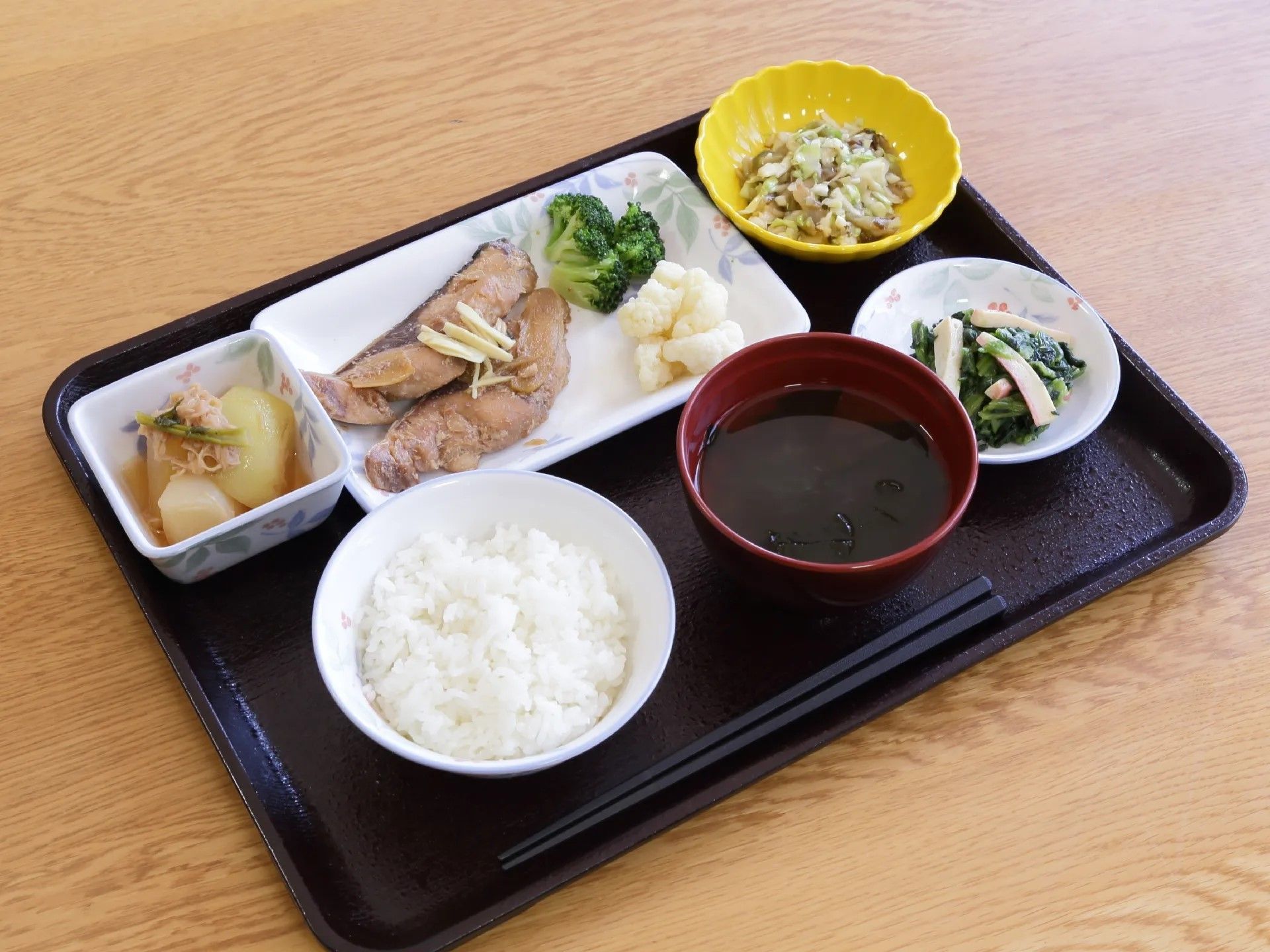 緑色のクロスのかかったテーブルを囲み食事を楽しむ５人