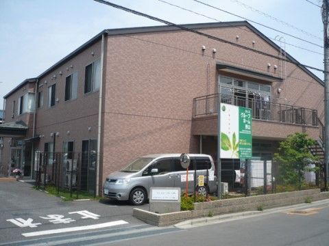 道路に面した三角屋根で、ブラウンの外壁の二階建て建築