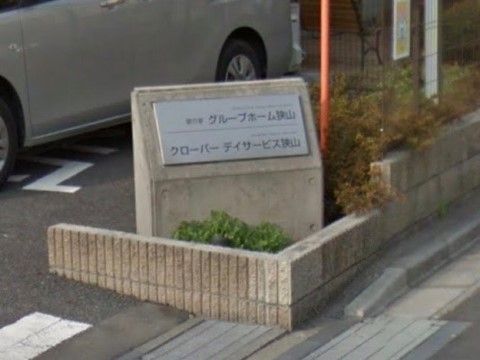 駐車場の入口にホーム名を記したプレートを、コンクリート製の看板に設置している。ホームとデイサービスが併設する施設である。
