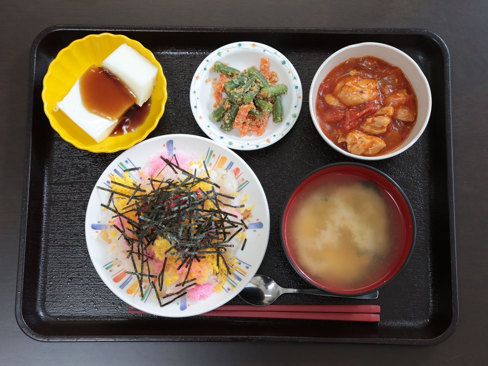 一人分の食事がお盆にのっている。ちらし寿司、汁物、主菜に副菜が2品。見た目が鮮やかで食欲がそそられる。